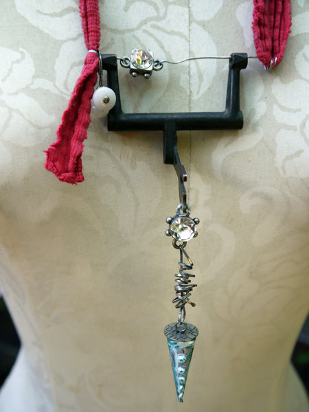 Recycled sewing machine part with hanging charm necklace
